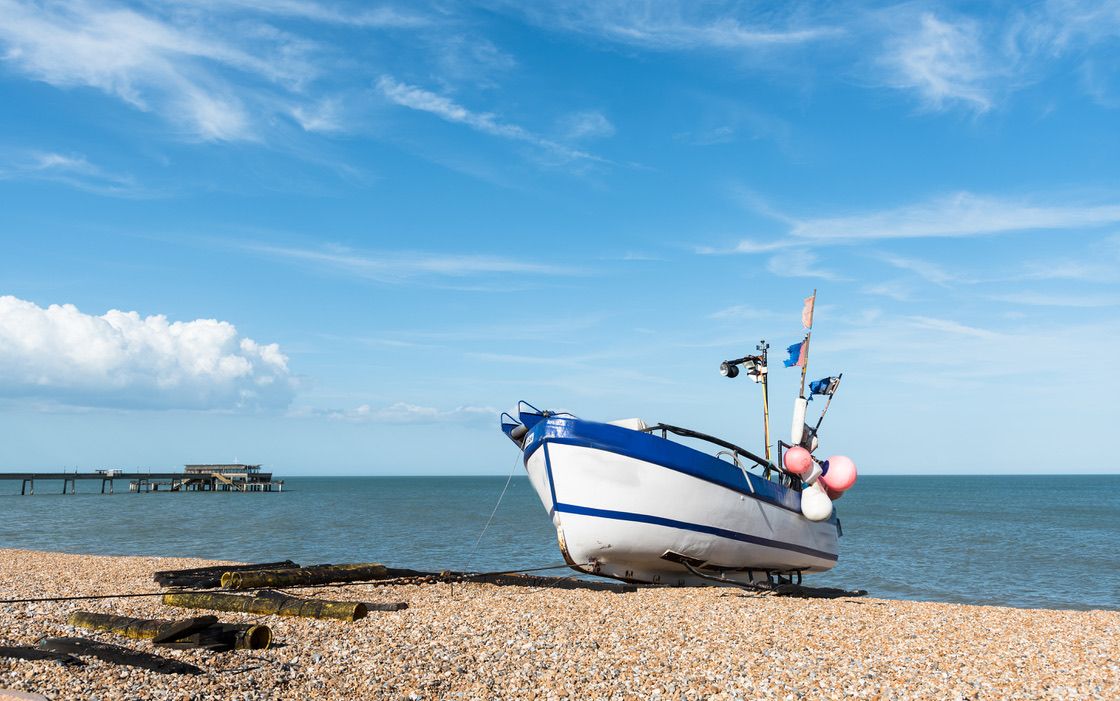 Lonely fishing Boat at the coast and cloudy blue sky.