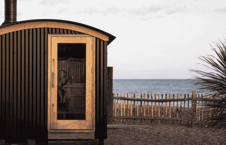 A nordic-style beachfront sauna with the sea in the background.