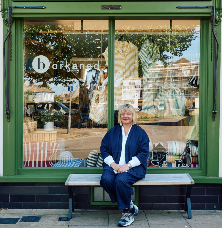 The owner of Barkened, an independent goods store in Deal, Kent sitting outside the shop.